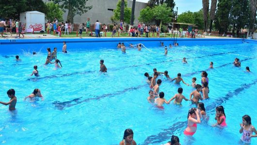 Pileta de natación de grandes dimensiones con niños y adolecestes en su interior