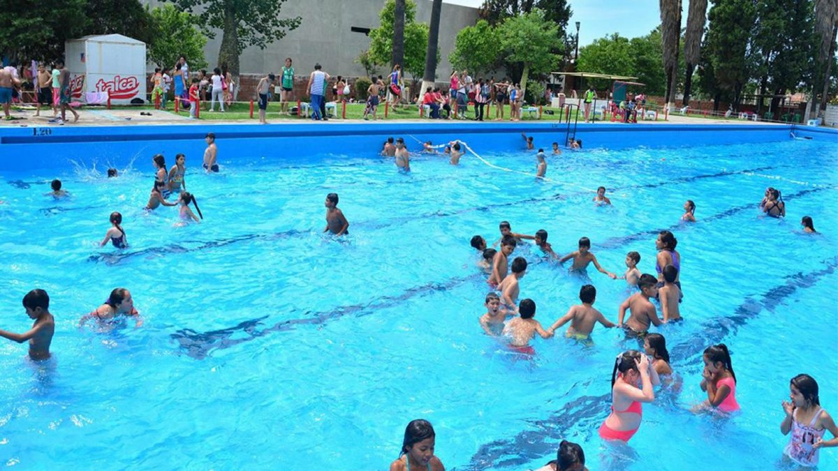 Pileta de natación de grandes dimensiones con niños y adolecestes en su interior